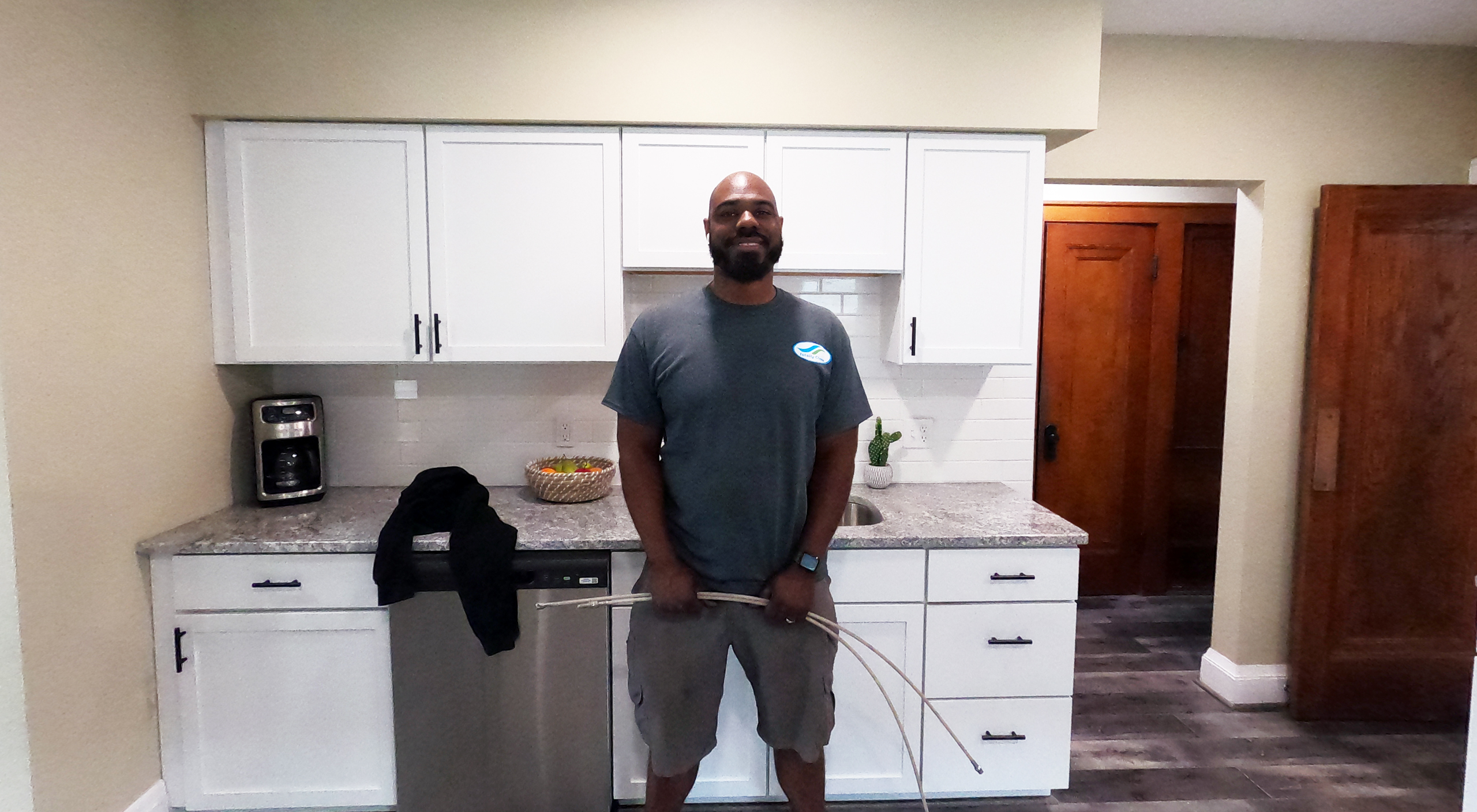 Air Duct Cleaning Caledonia, WI 8 Owner Operator, James Green standing in front of kitchen cabinets, smiling and holding an air duct cleaning tool.
