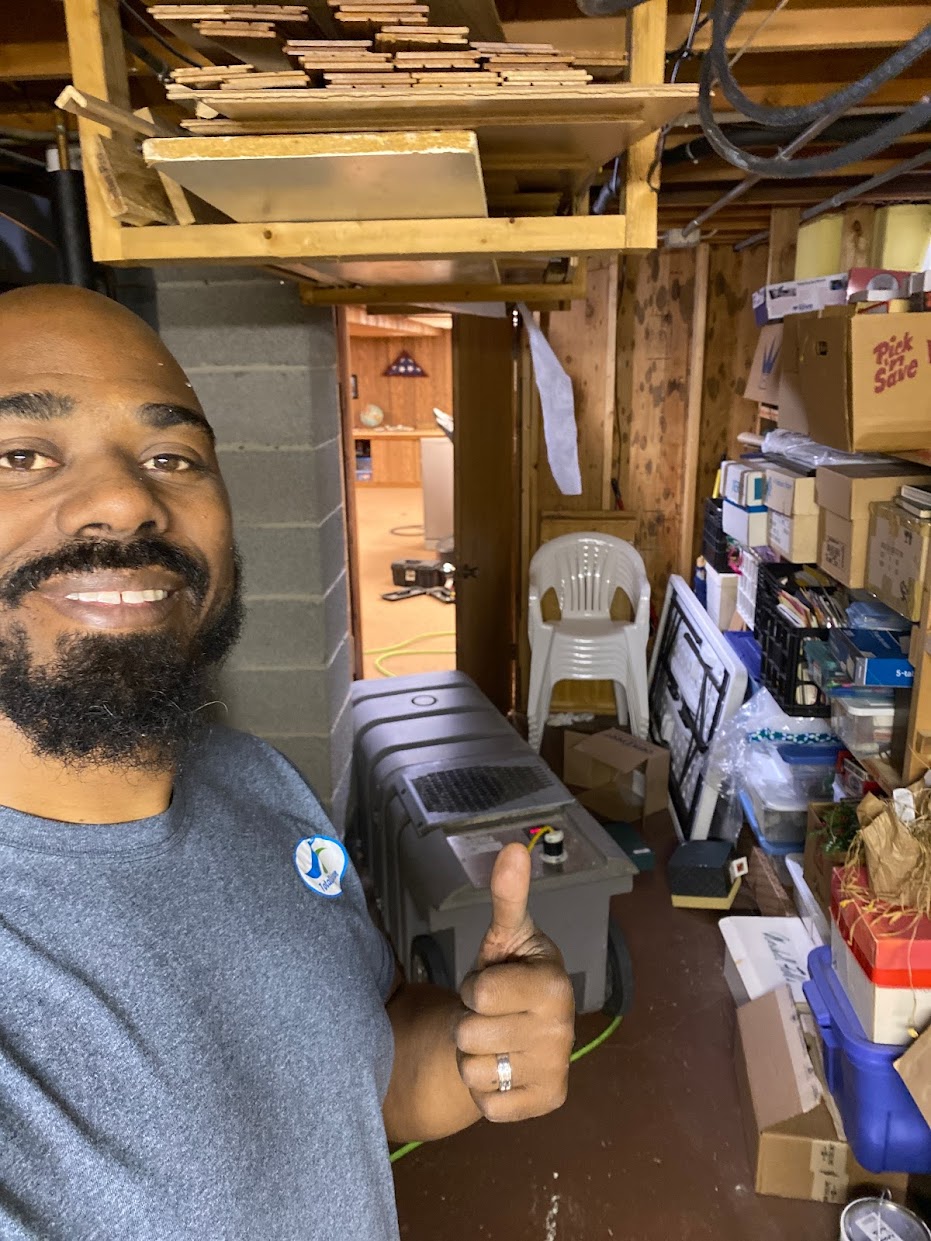 Owner Operator, James Green standing in front of kitchen cabinets, smiling and holding an air duct cleaning tool in a Milwaukee residential home.