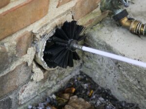 dryer vent cleaning tool being inserted into dryer vent.