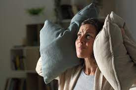 is air duct cleaning loud, woman holding pillows over ears.