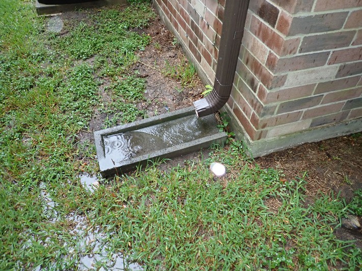 Splash block placed at the base of a downspout.