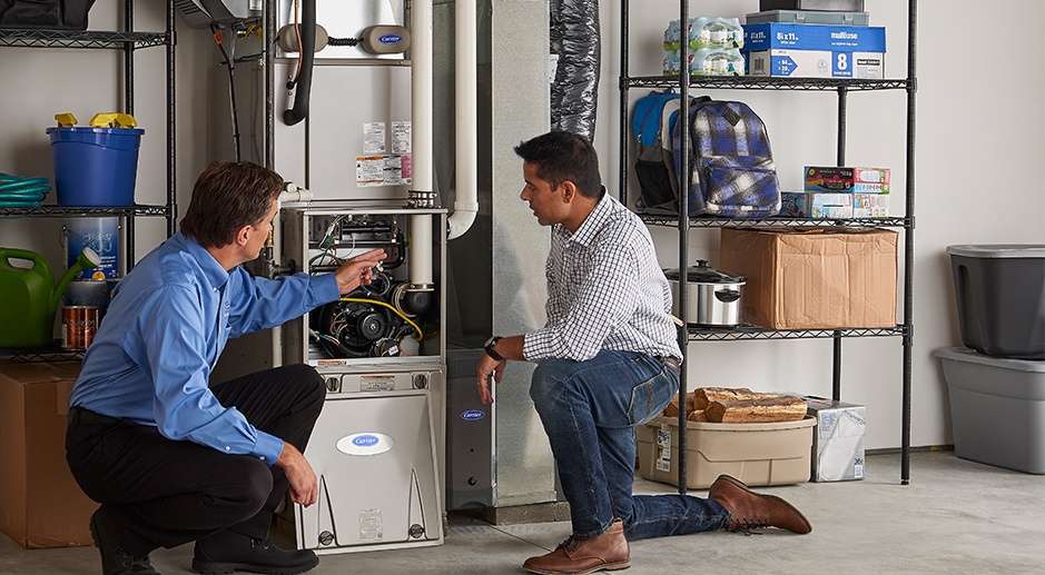 HVAC technician showing a customer the inside of their furnace.