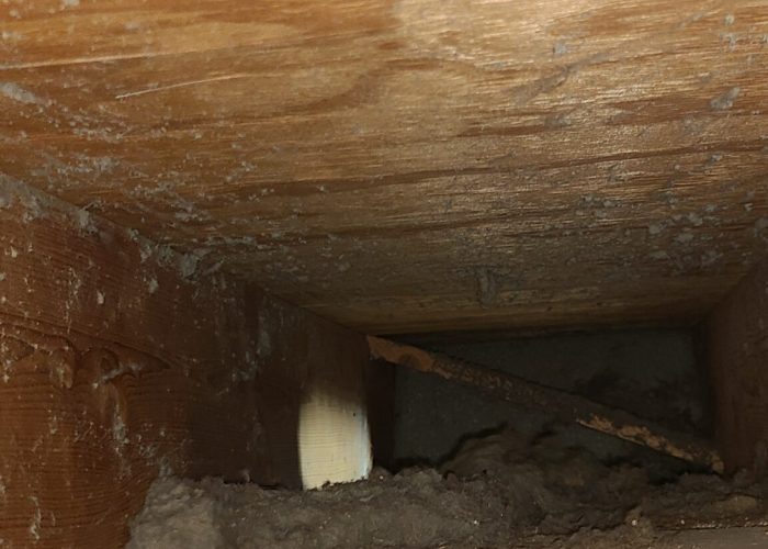 Return ducting with drywall chunks and dust covered on the walls and base of venting.